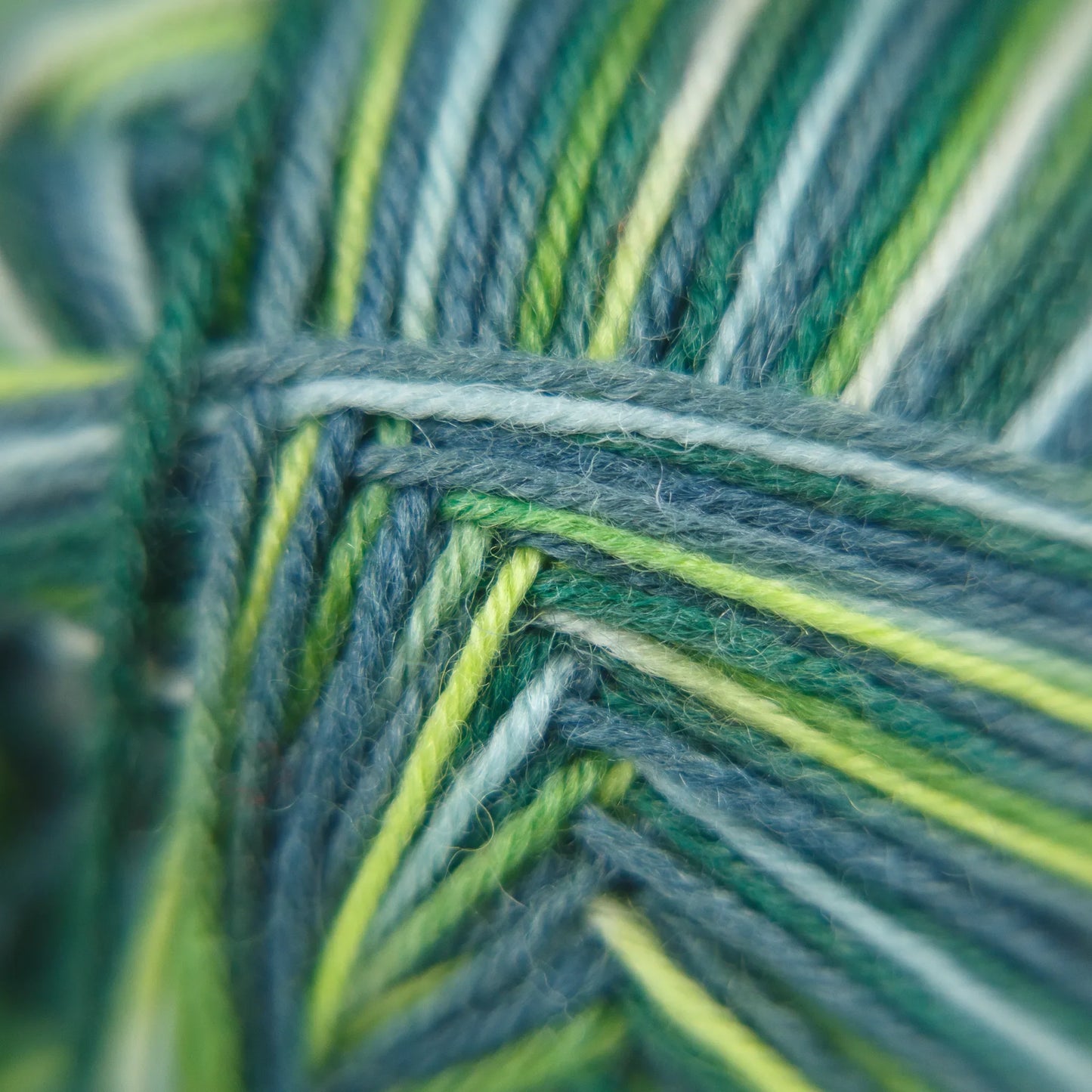 Macro close-up of Sock Flock Wild Pear yarn showing colour shift across pink, blue, and neutral tones