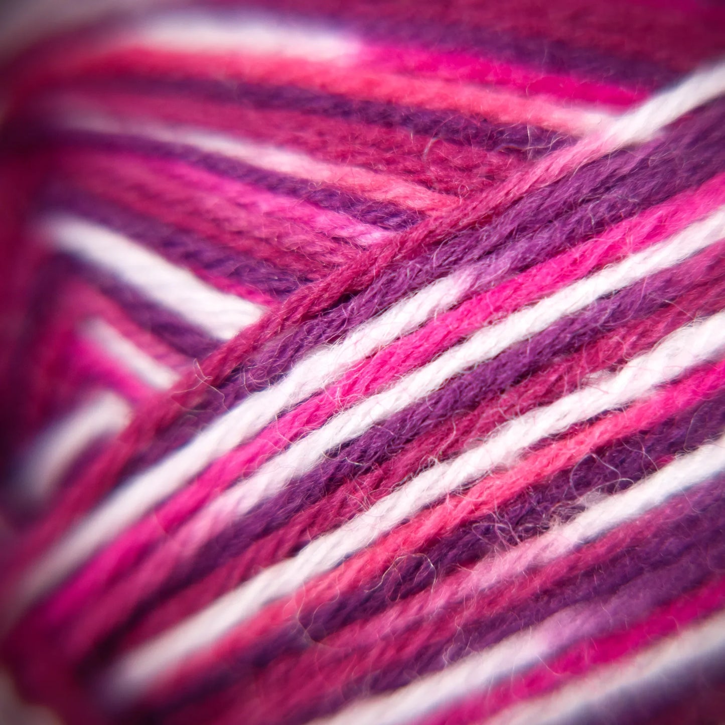 Close-up of Raspberry Ripple yarn showing high-fibre twist and multicolour blend across strands.