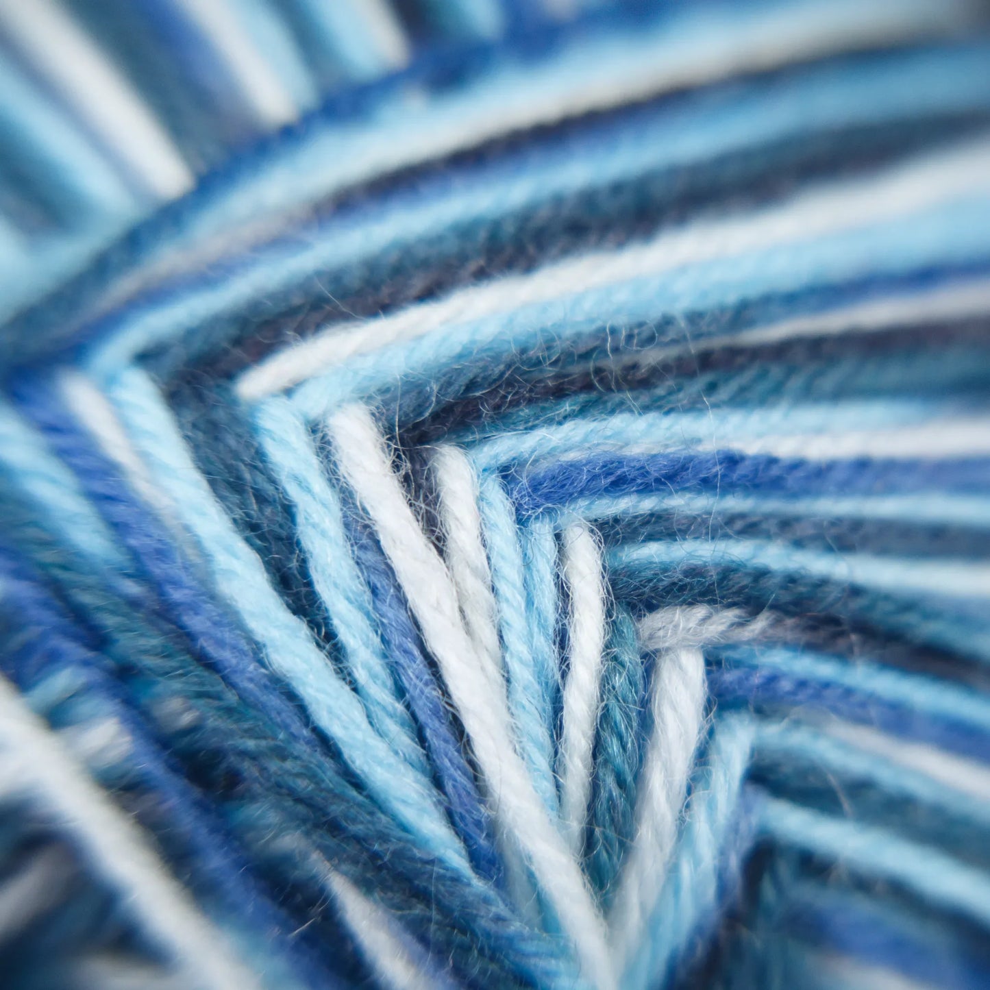 Macro of Sock Flock Arctic Ocean yarn, showing tonal blue, off-white and steely grey ply.