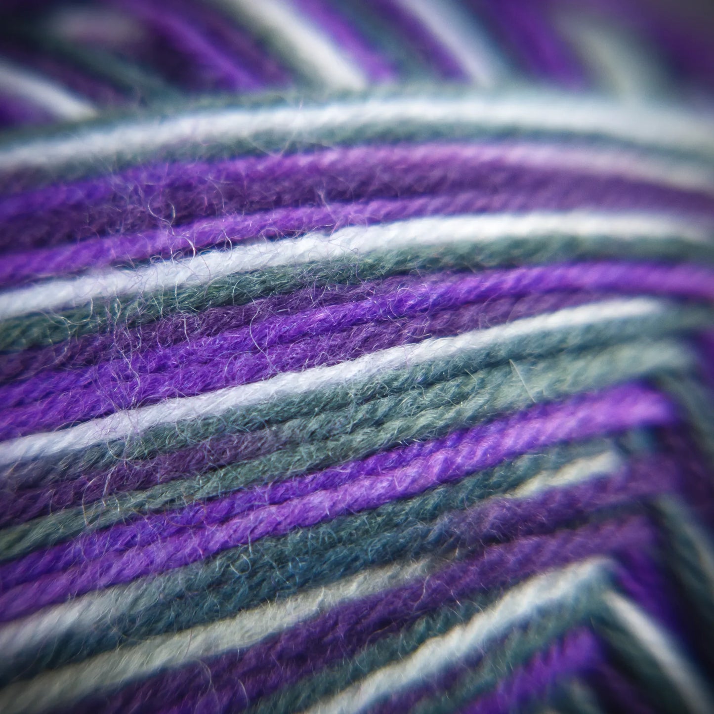 Fibre-level photo of Purple Ivy yarn showing moody tone mix and soft twist definition.