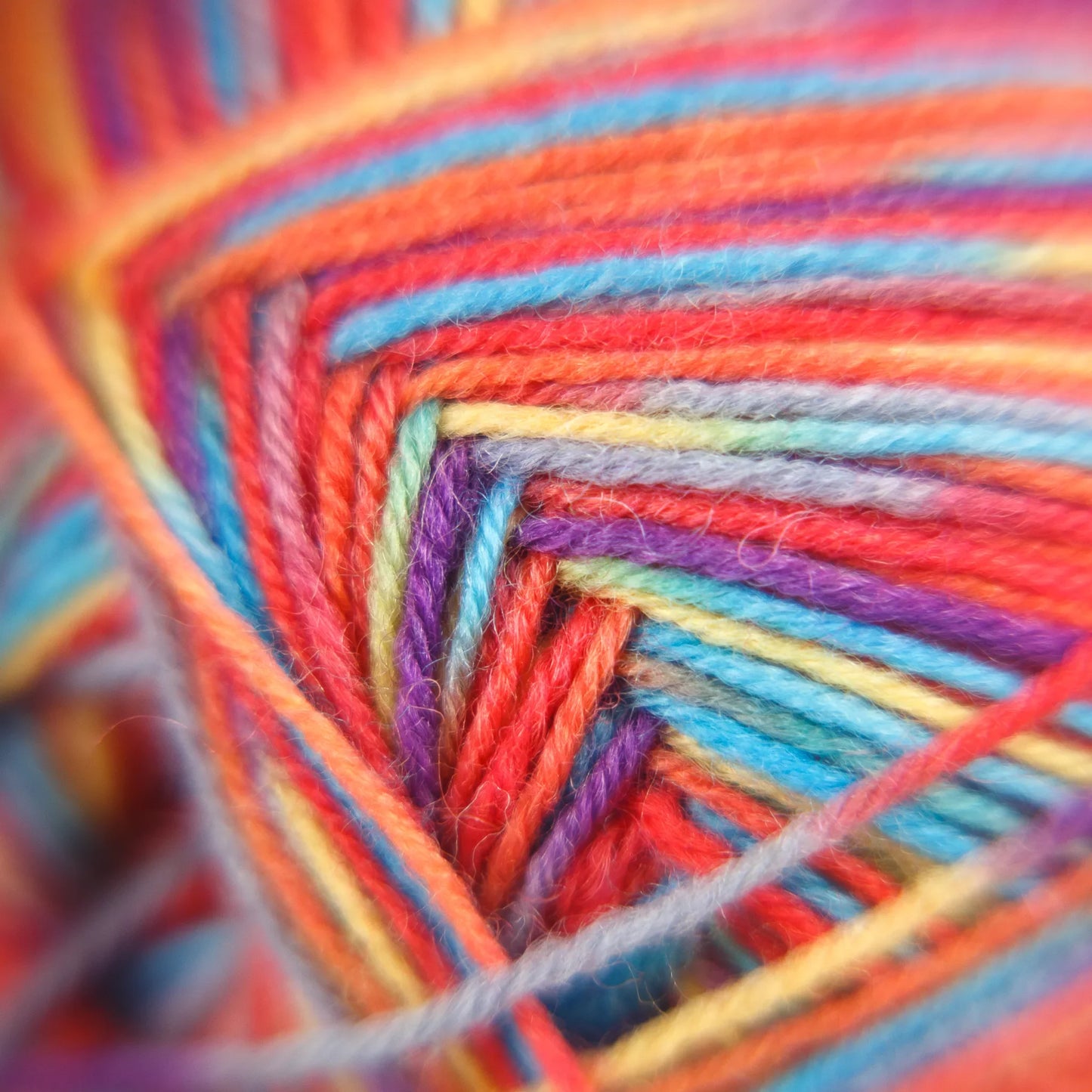 Macro fibre photo of Sock Flock ‘Rainbow Reef’ yarn in playful hues of pink, aqua, apricot and yellow.