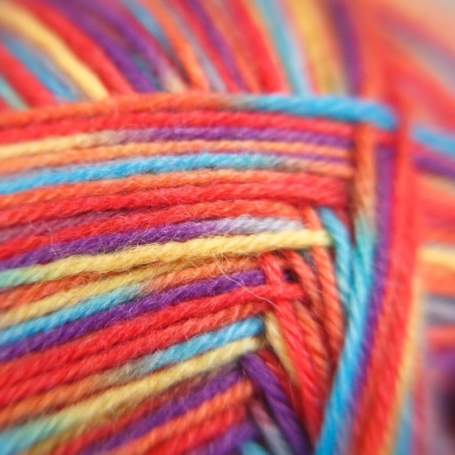Macro detail of Rainbow Reef yarn showing multi-tone twist in tropical-inspired pastel-to-bold spectrum.
