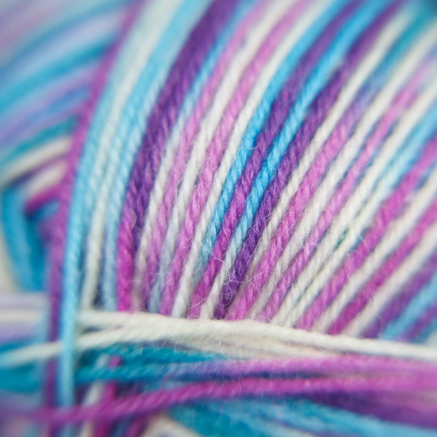 Macro photo of Sock Flock ‘Sea Glass’ yarn, showing clear fibre structure in layered ocean tones.