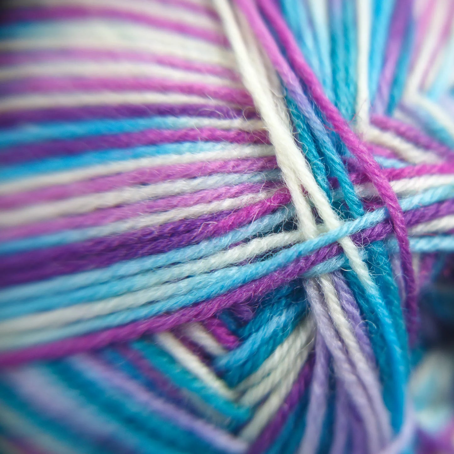 Fibre-level macro photo of Sea Glass yarn in soft pastel green and natural cotton undertones.