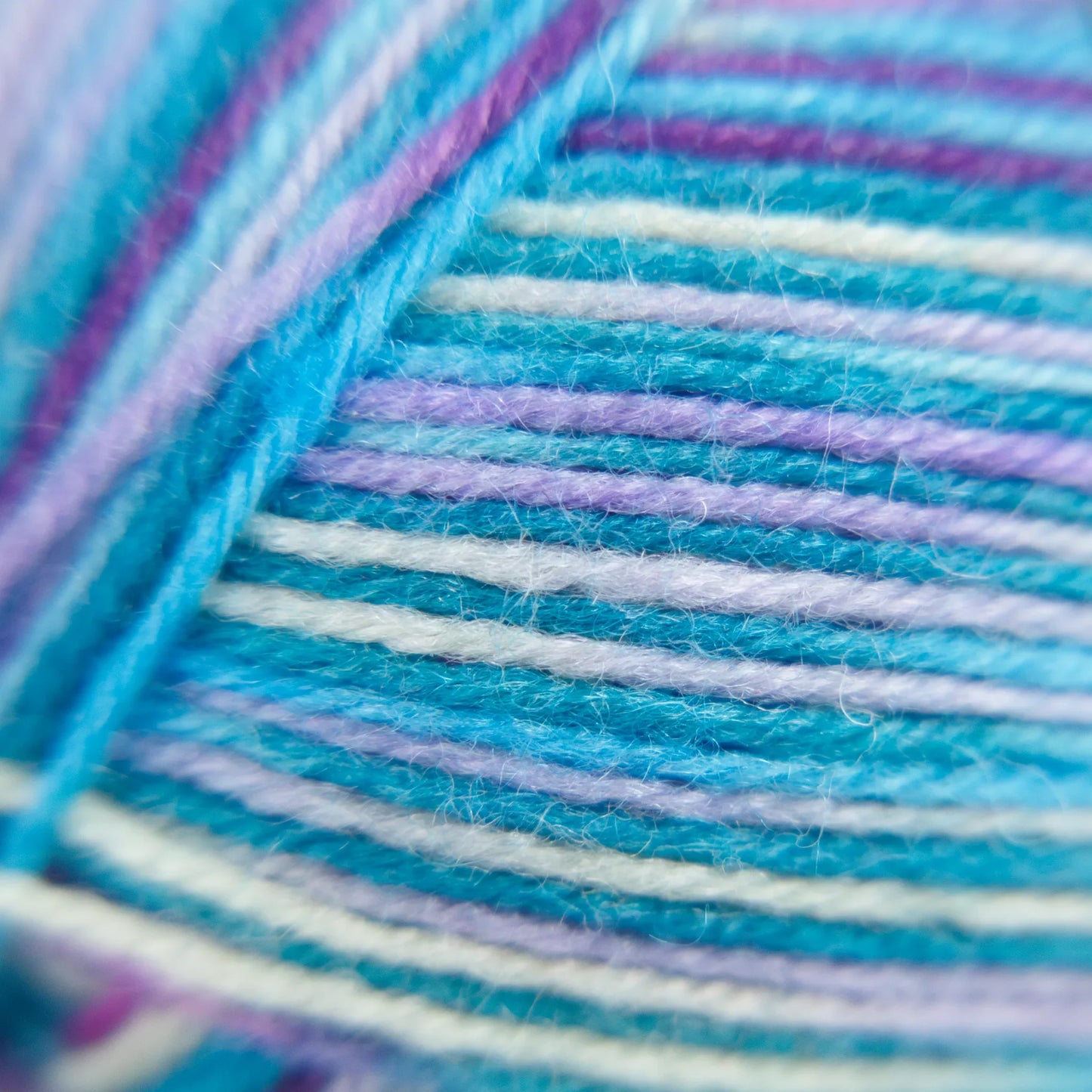 Macro photo of Sea Glass yarn with soft aqua-green strands and chalky white flecks.