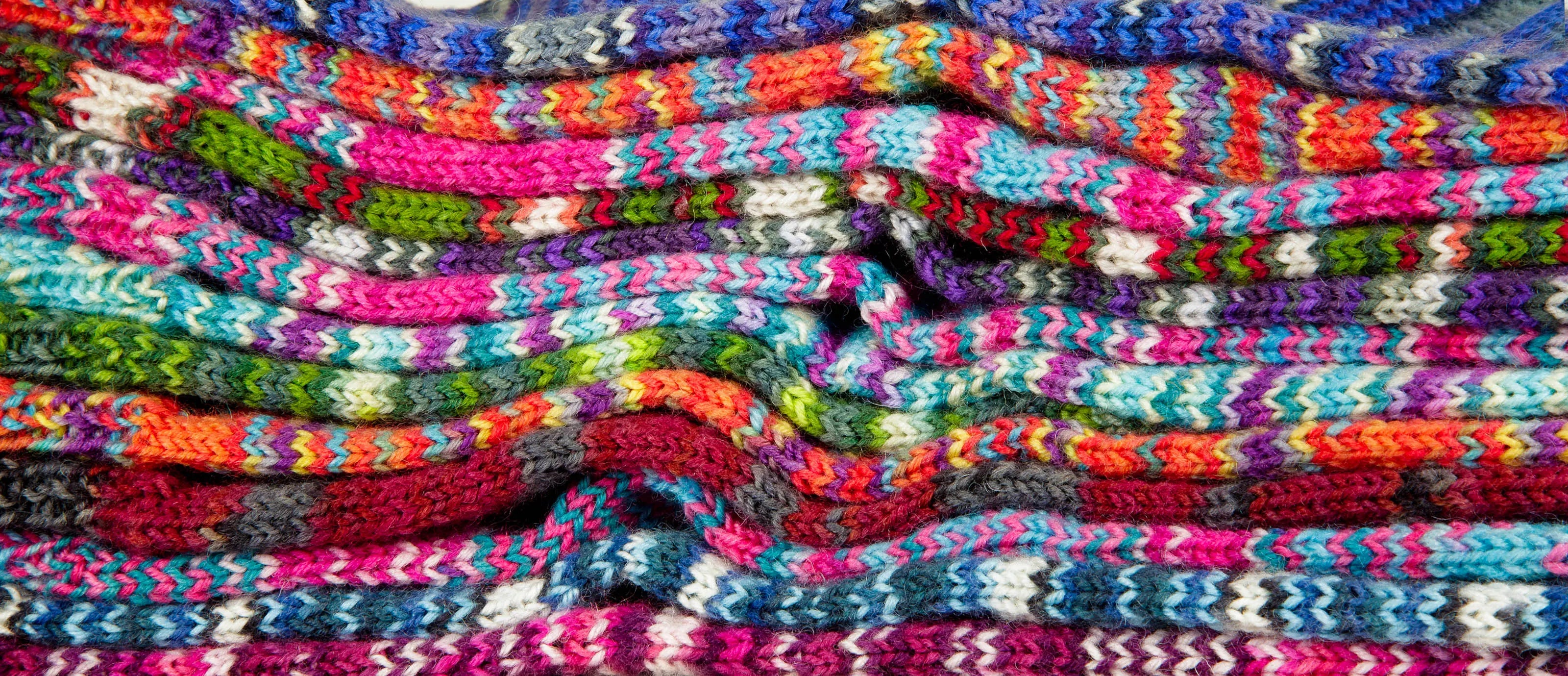 Flattened side-by-side Sock Flock socks arranged in dense horizontal layers — an artistic, macro cross-section that reveals stitch detail and tonal variation across the complete range.