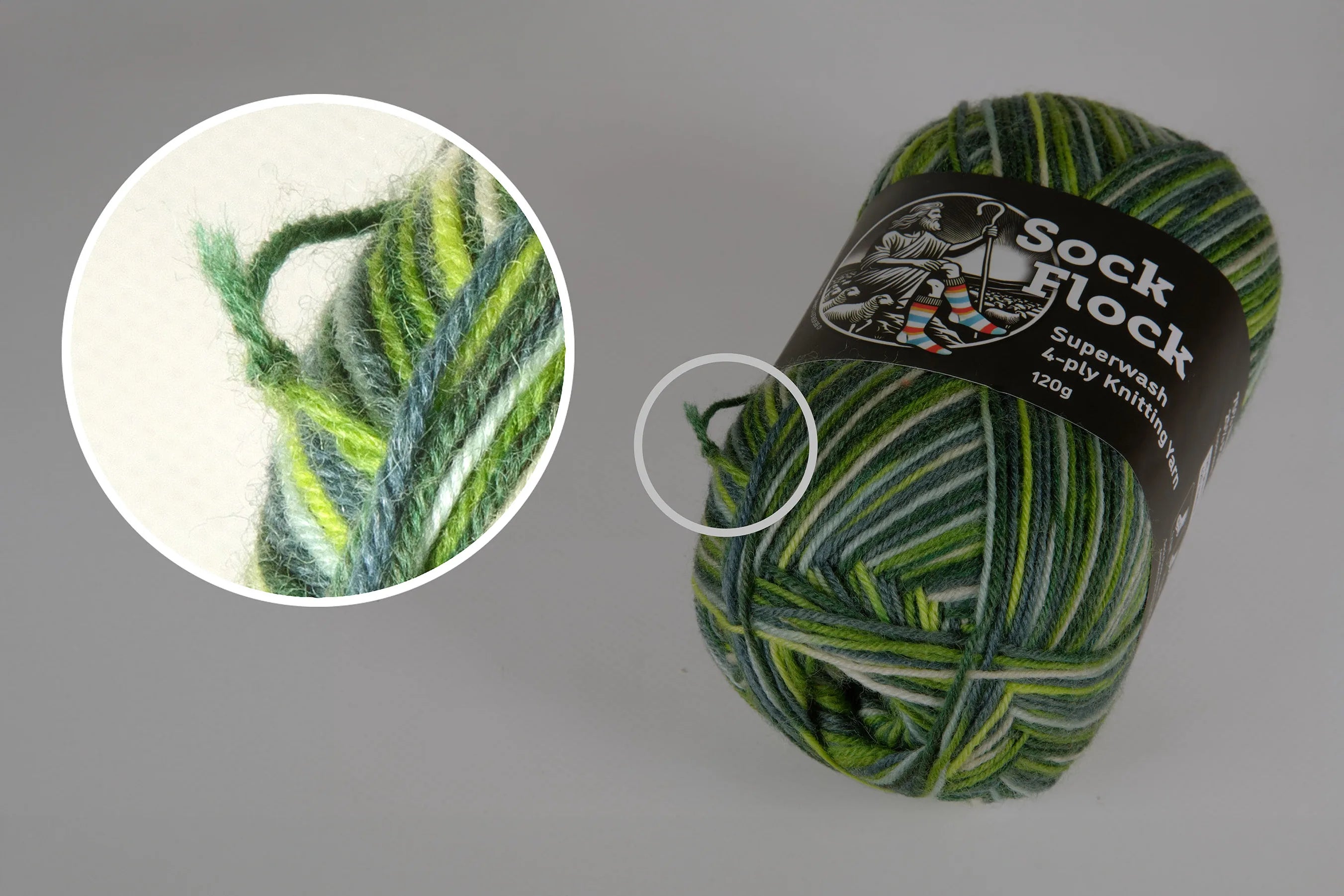 Green variegated sock yarn ball by Yarn by Clarke showing a factory knot close-up, demonstrating natural joins in manufacturing.
