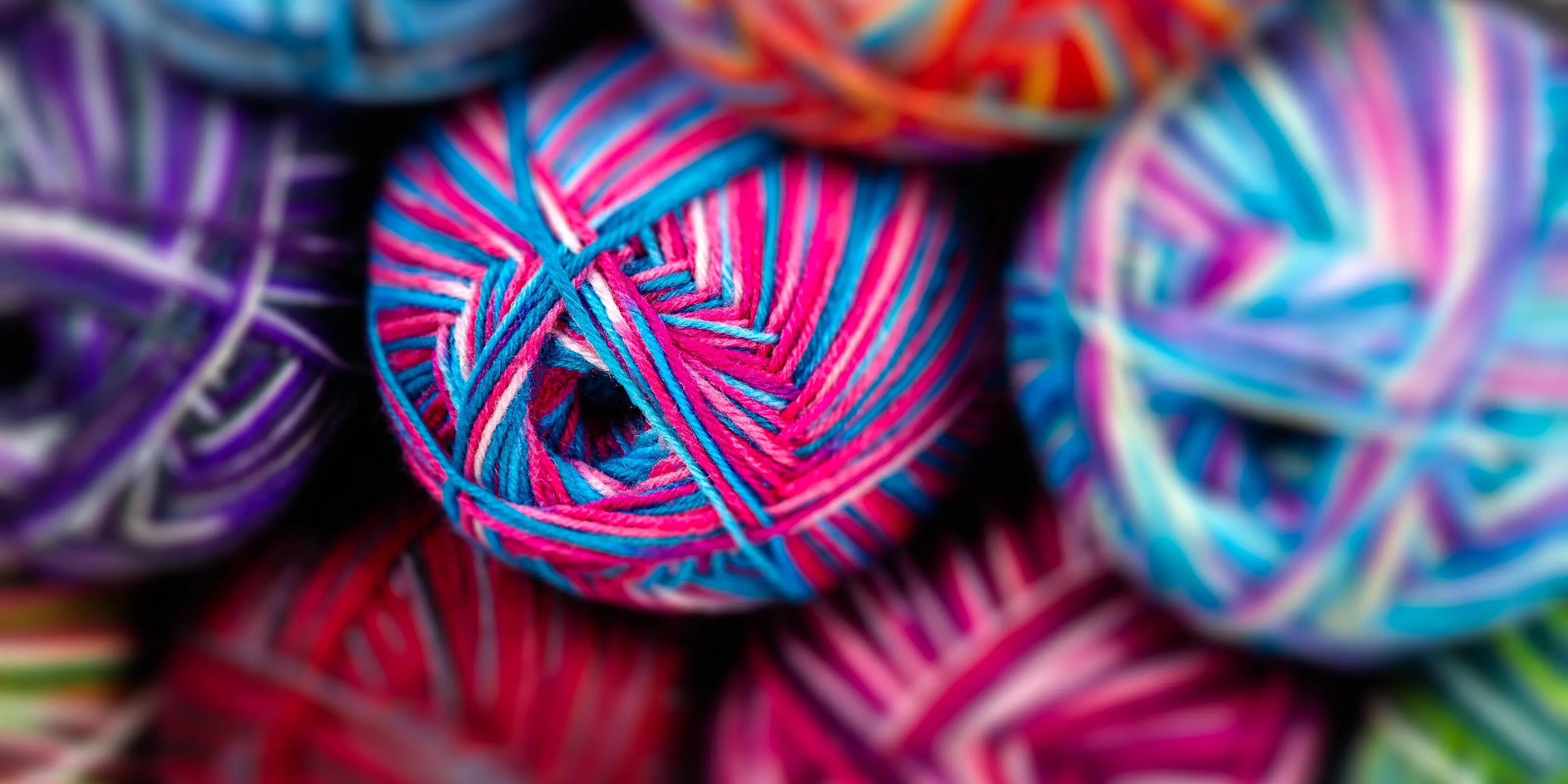 Richly coloured Sock Flock yarn bundles centered around Sakura Spring, styled in a tight promotional cluster to showcase depth and quality of product range.