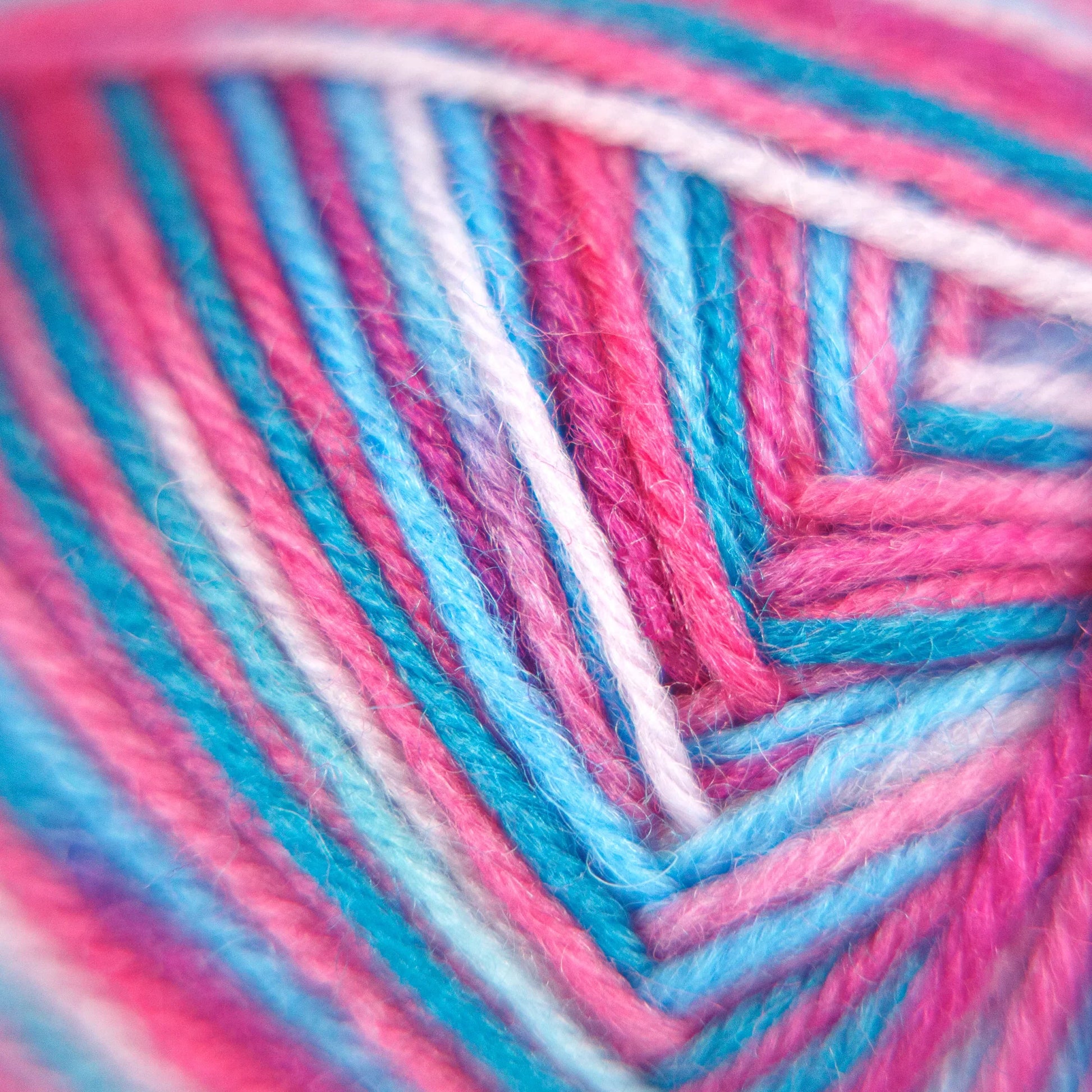 Macro close-up of Sock Flock – Sakura Spring yarn strands showing vivid pink, aqua blue and white fibre tones