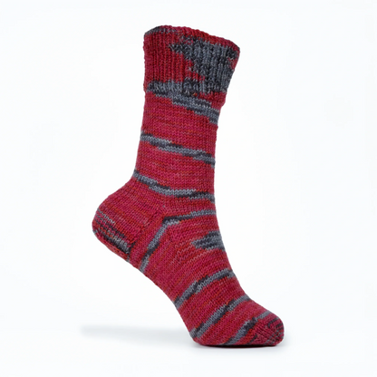 Right sock knitted in Roasted Fig yarn, displayed on mannequin foot against white background with natural stripe flow.
