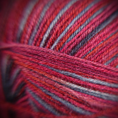 Fibre-level close-up of Roasted Fig yarn, showing twist detail and variegated mulberry, wine, and violet tones.