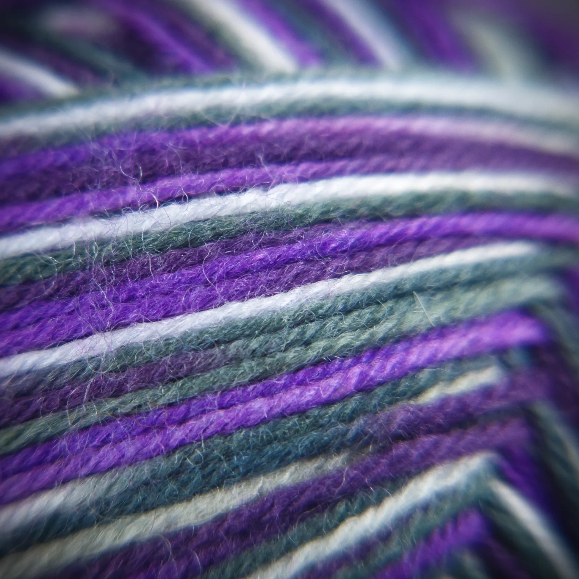 Fibre-level photo of Purple Ivy yarn showing moody tone mix and soft twist definition.