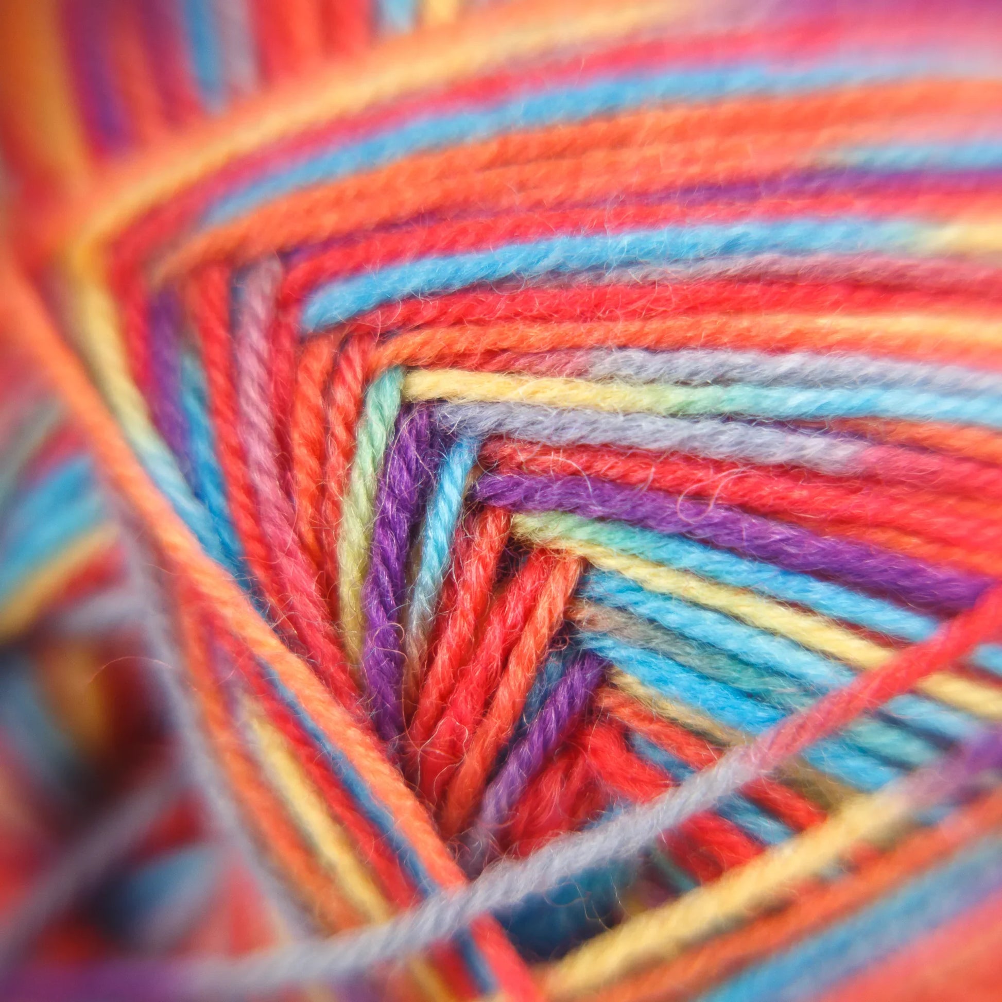 Macro fibre photo of Sock Flock ‘Rainbow Reef’ yarn in playful hues of pink, aqua, apricot and yellow.