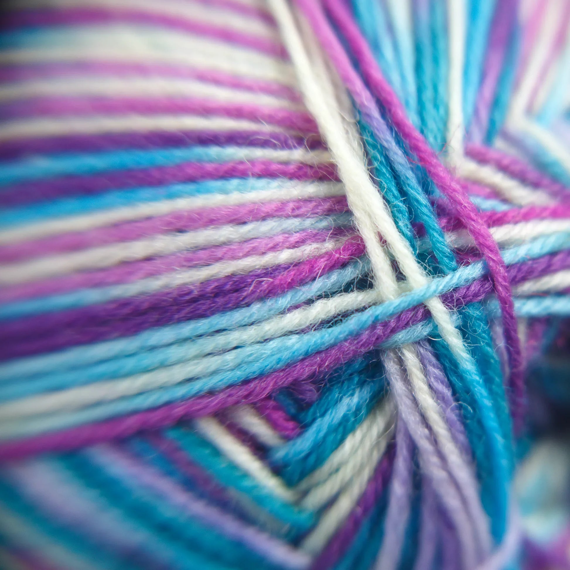 Fibre-level macro photo of Sea Glass yarn in soft pastel green and natural cotton undertones.